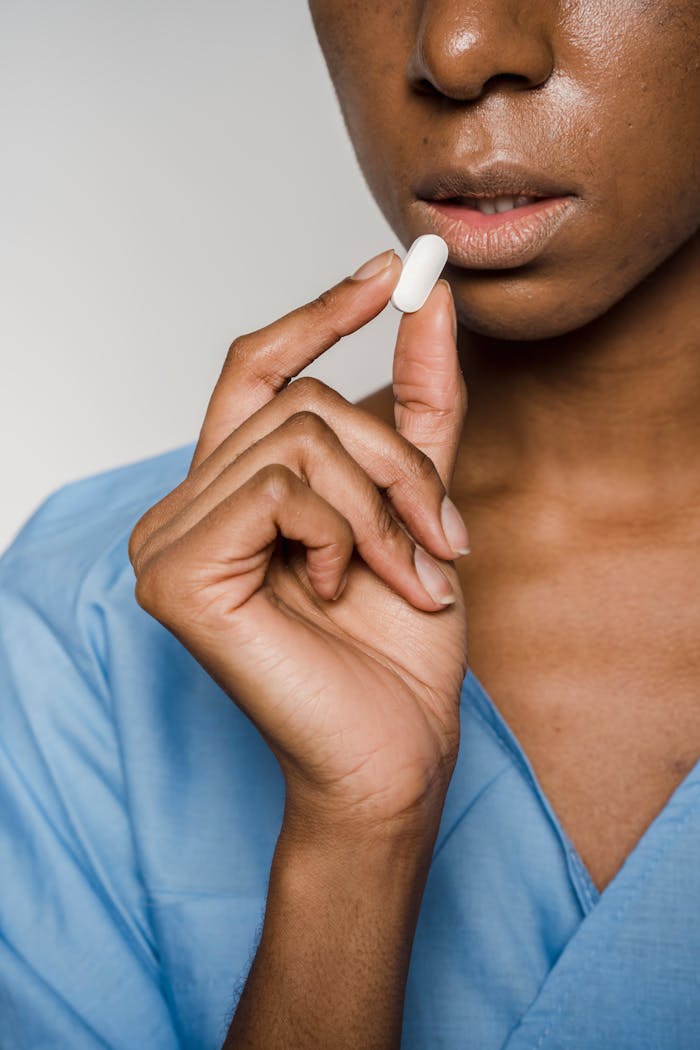 A close-up of a woman holding a pill shows a healthcare or medication concept.
